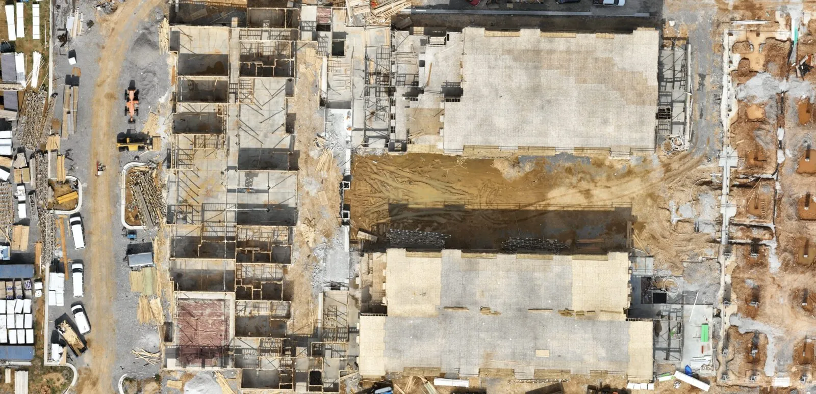 Top-down orthomosaic of a commercial building under construction with formwork and material laydown