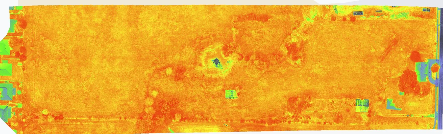 Wide vegetation index map across a long parcel, showing vigour variation from green through orange to red.